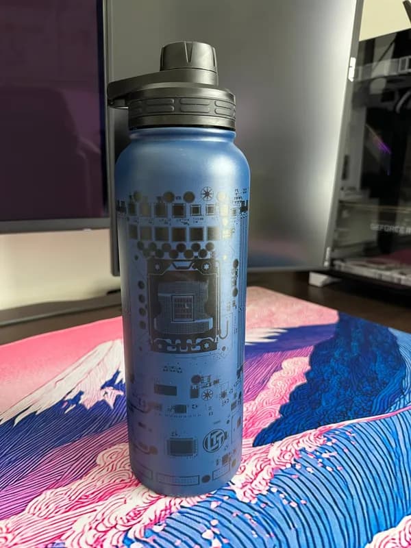 Phone photo of a blue water bottle on a desk in front of a monitor
